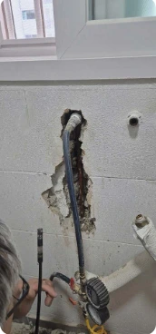 작업자가 현장에서 배관을 살펴보는 모습